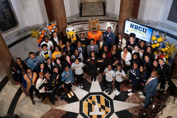 Mayor Brandon M. Scott with a large group of people and Morgan State and Coppin mascot characters
