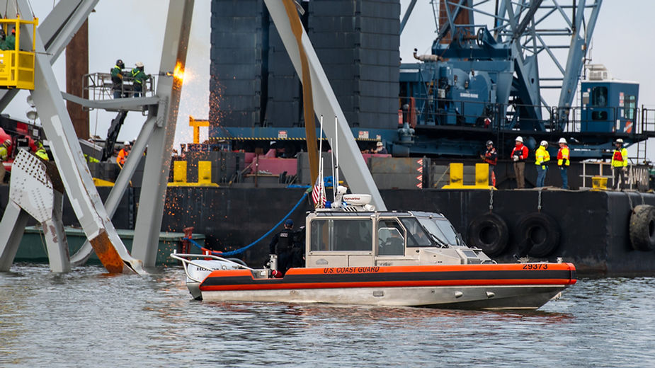 Coast Guard boat next to wreckage of bridge