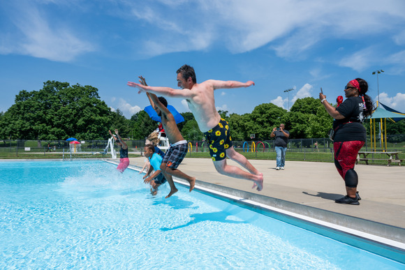 People jumping into a pool at Patterson Park Pool